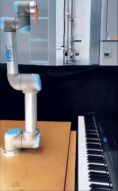 A robot arm pressing piano keys while learning a playing style
